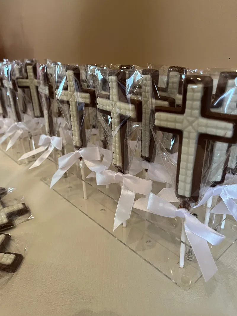 Chocolate cross pops tied with white satin bows for a first communion celebration in Charleston